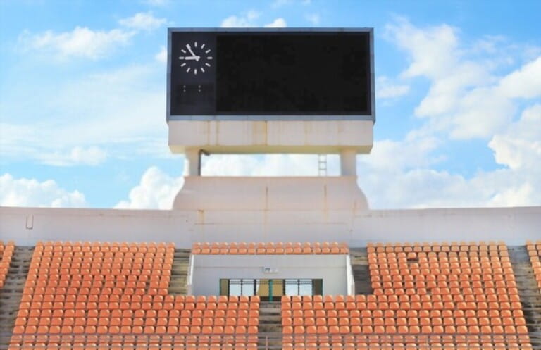 Scoreboard, orange seat in stadium with cloud and blue sky backg