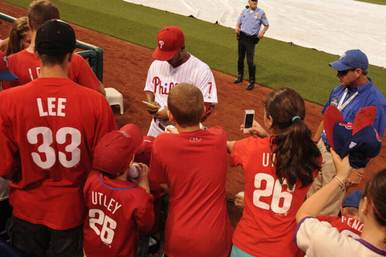 The Philadelphia Phillies 2nd baseman Michael Martinez signs autographs as thunderstorms bear down on the stadium Friday night, June 22nd. 