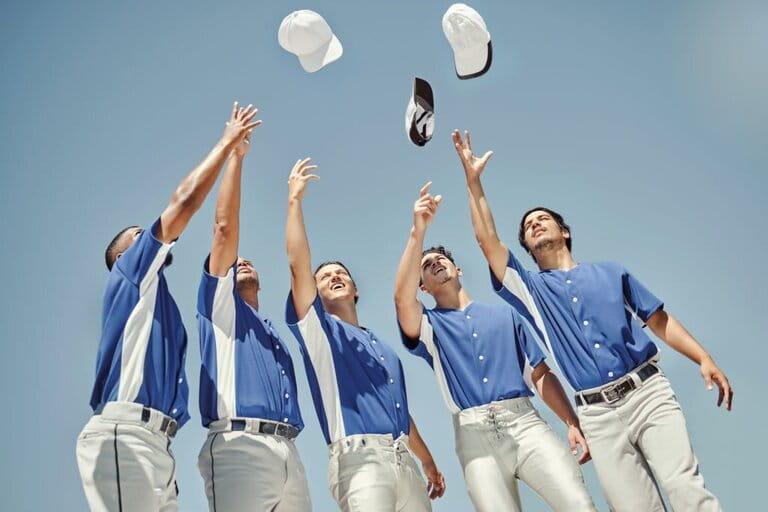 Baseball, hat and team in celebration at a game, solidarity for sport and support for partnership. A group of athletes throw hats for success, to win and to celebrate