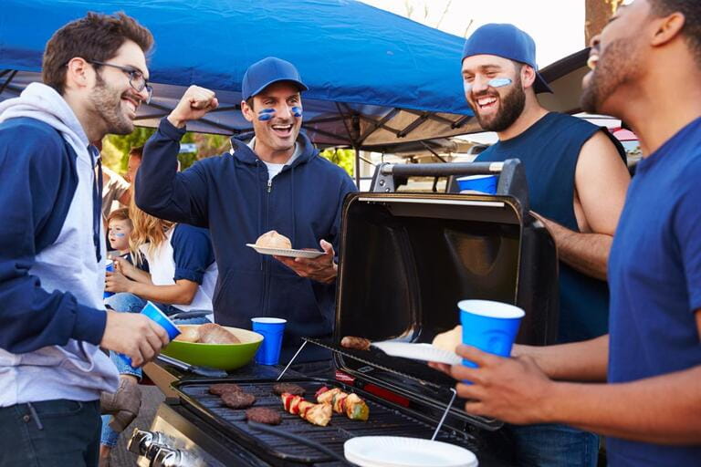 Tailgating male sports fan group In the parking lot stadium